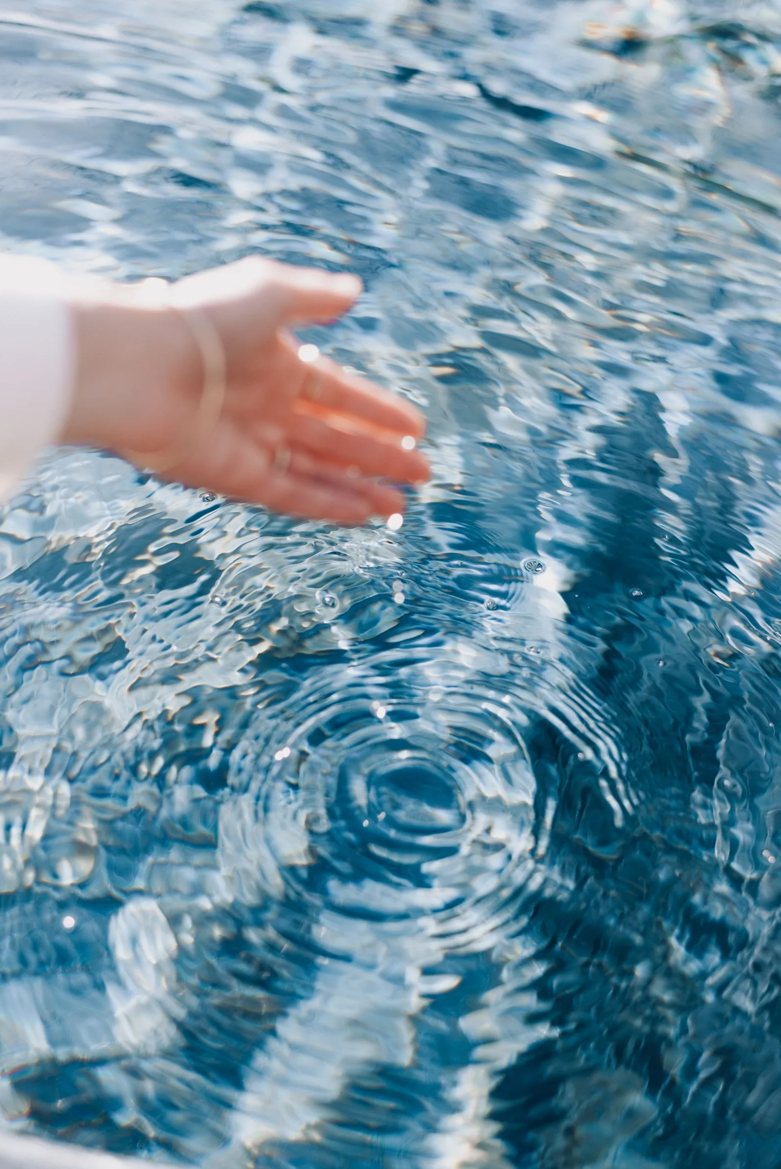 Mano tocando agua limpia